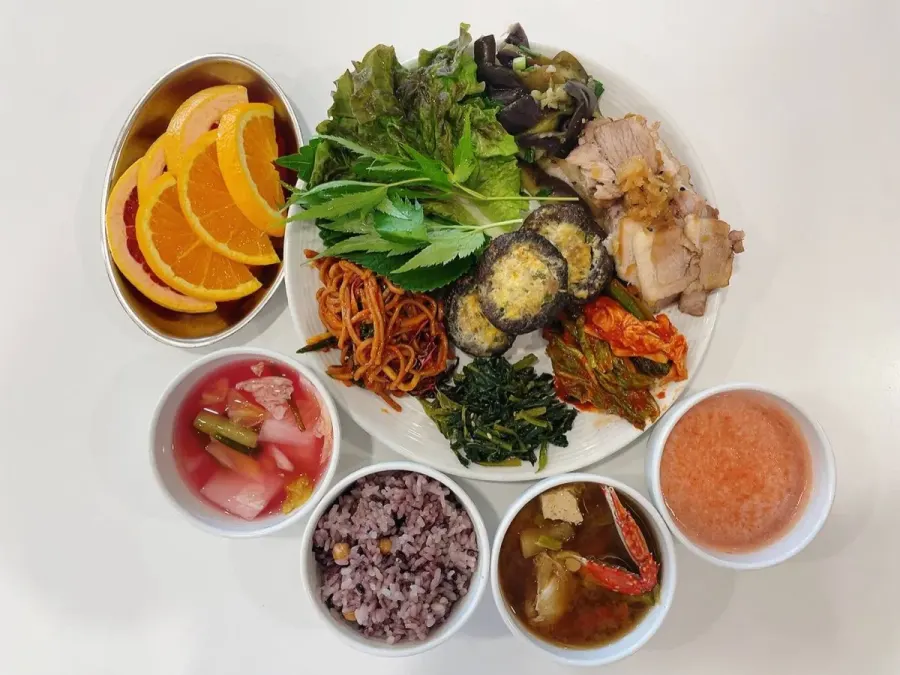 흑미 잡곡밥, 수육과 쌈채소, 표고버섯전, 잡채, 시금치나물, 게 미역국, 과일